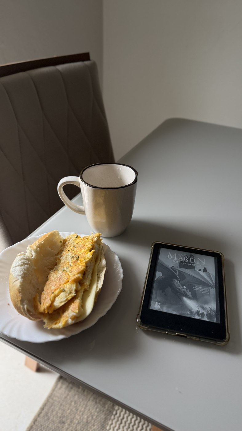 Café da manhã sem pressa: caneca, prato e leitor de e-book